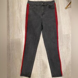 Black skinny jeans in a US size 30 with two red lines going down the sides.